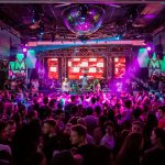 Dynamic crowd at a lively nightclub in Mantua, Italy, with vibrant lights and energetic atmosphere.